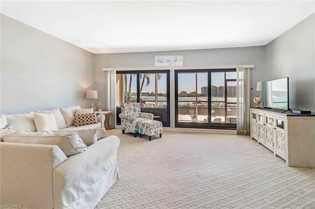 400 La Peninsula Boulevard, Unit 404 Naples, FL 34113 - Photo 7 of 19 a living room with furniture and a flat screen tv