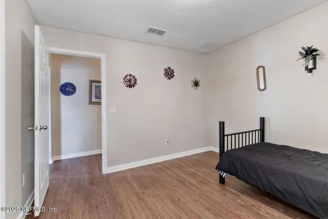 a bedroom with a bed and wooden floor