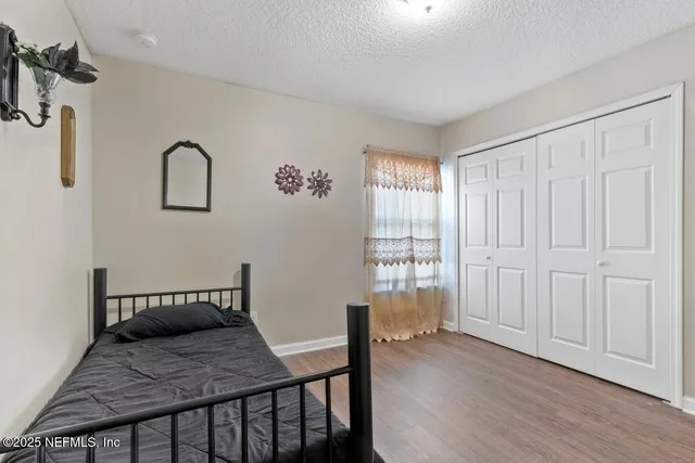 a bedroom with a bed and wooden floor