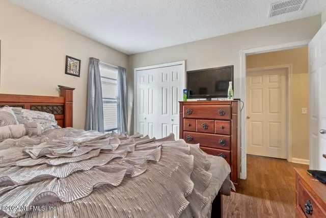 a bedroom with a bed and flat screen tv