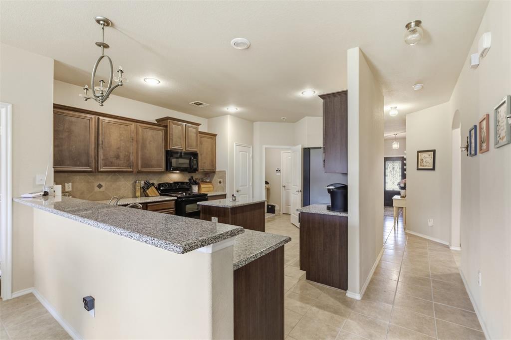5491 Exeter Drive Prosper, TX 75078 - Photo 6 of 20 a kitchen with stainless steel appliances granite countertop a sink stove and refrigerator