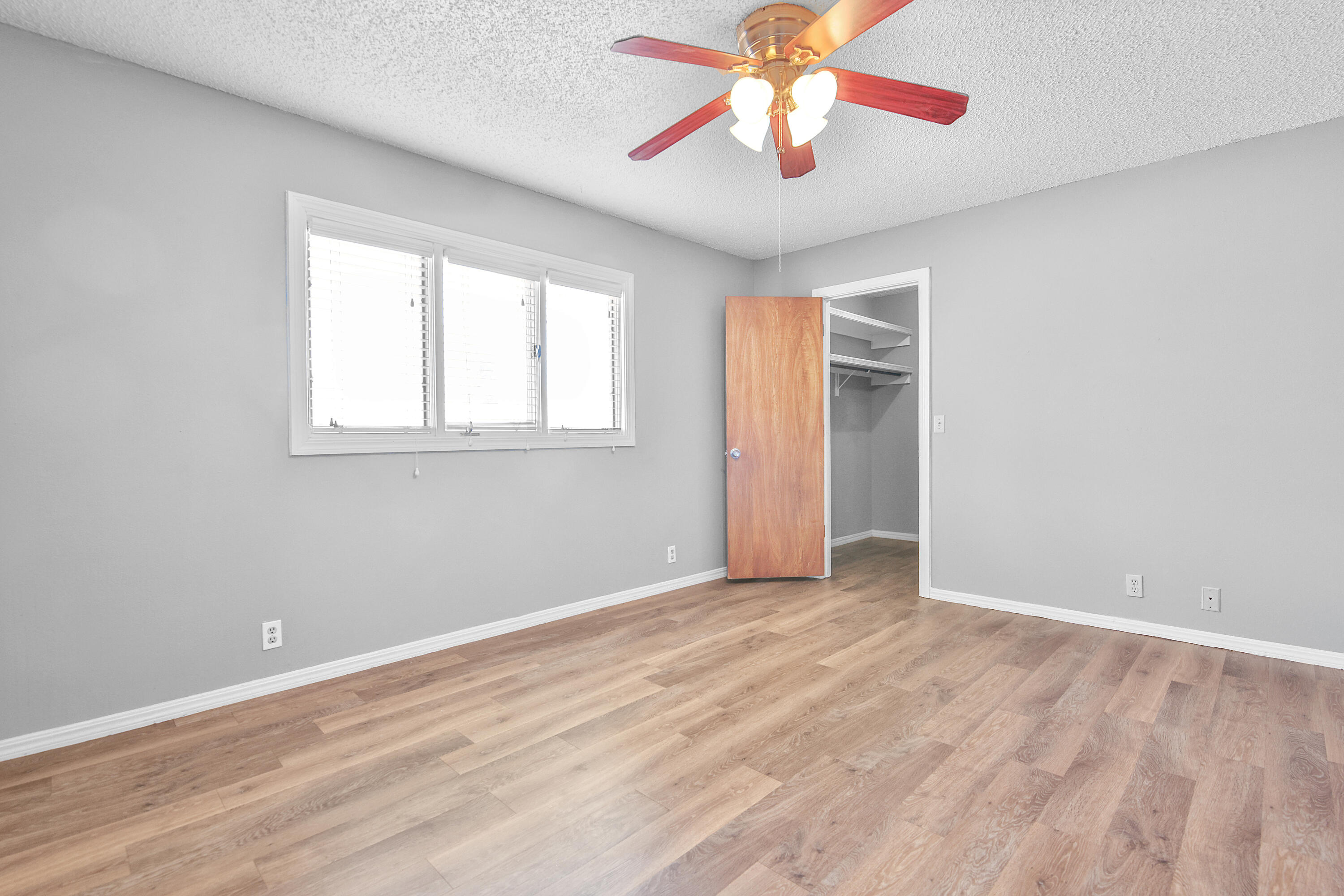18 Highland Drive Ransom Canyon, TX 79366 - Photo 20 of 28 an empty room with wooden floor chandelier fan and windows