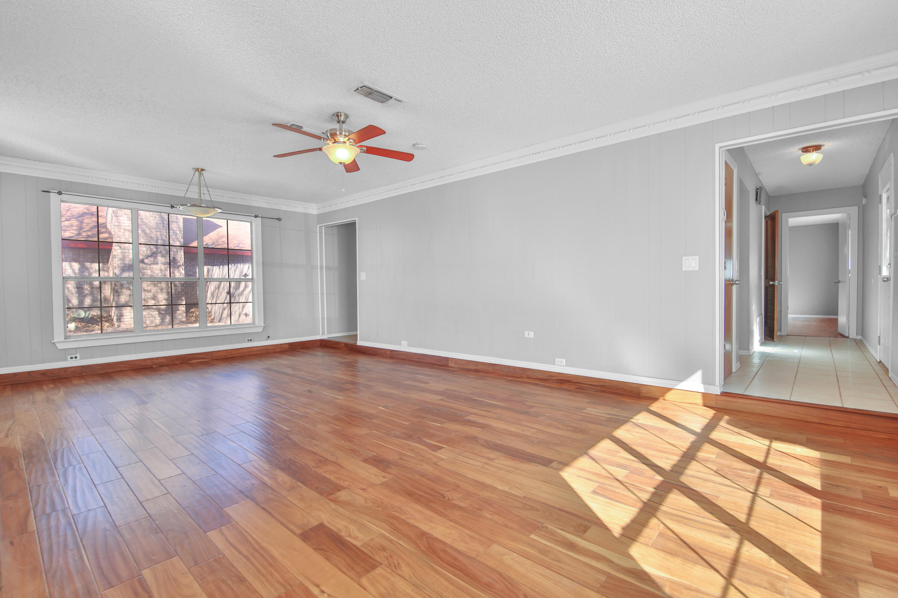 18 Highland Drive Ransom Canyon, TX 79366 - Photo 6 of 28 an empty room with wooden floor chandelier fan and windows