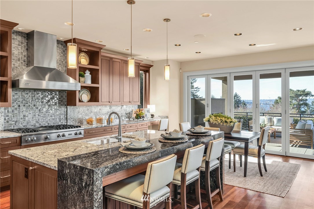 8477 Ridge Road Medina, WA 98039 - Photo 4 of 24 a kitchen with stainless steel appliances granite countertop a stove a refrigerator a kitchen island a table and chairs