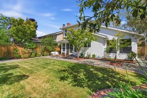 a view of a house with backyard and sitting area