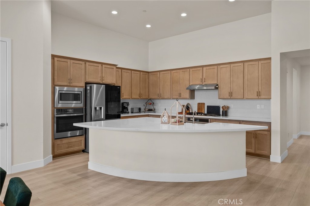 34972 South Serrano Square Yucaipa, CA 92399 - Photo 11 of 48 a view of a kitchen with kitchen island a sink stainless steel appliances and cabinets