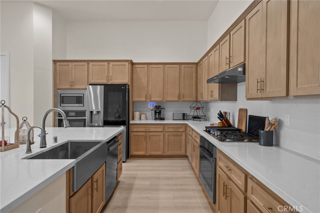 34972 South Serrano Square Yucaipa, CA 92399 - Photo 12 of 48 a kitchen with stainless steel appliances granite countertop a sink stove refrigerator and cabinets