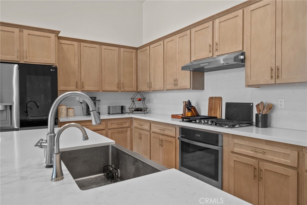 34972 South Serrano Square Yucaipa, CA 92399 - Photo 13 of 48 a kitchen with a sink a stove and cabinets