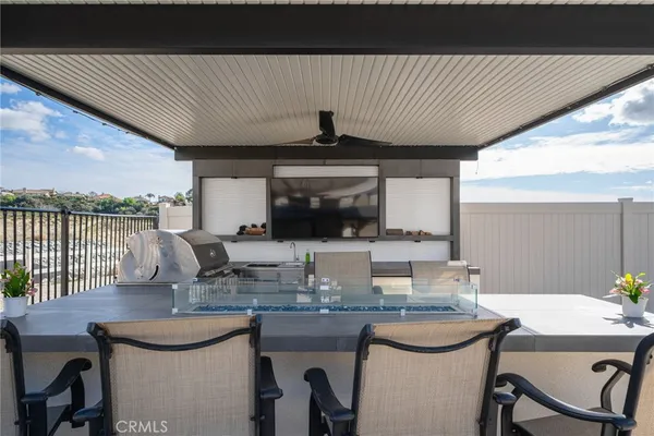 a room with stainless steel appliances kitchen island granite countertop a refrigerator a sink and wooden cabinets