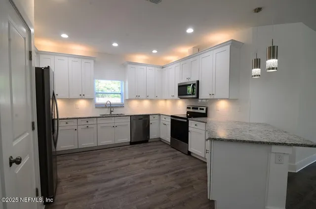 a kitchen with granite countertop sink and cabinets