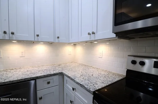 wooden floor in an empty room with kitchen view
