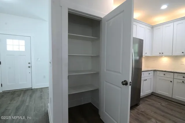 a kitchen with a sink cabinets and wooden floor