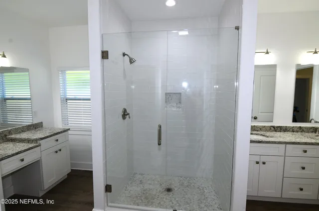 a bathroom with a granite countertop sink toilet and shower