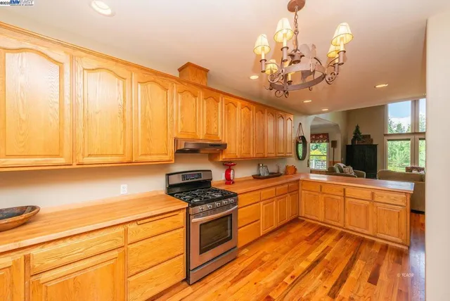 a kitchen with a sink stainless steel appliances cabinets and a large window