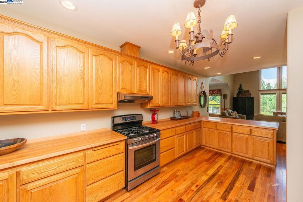 a kitchen with a sink stainless steel appliances cabinets and a large window