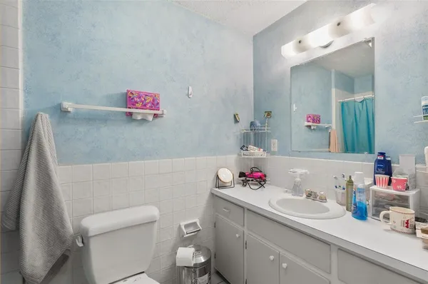 a bathroom with a sink vanity mirror and toilet