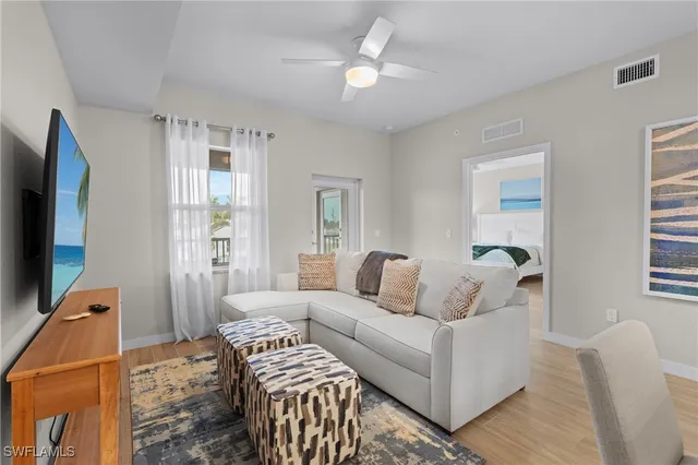 a living room with furniture a flat screen tv and a window