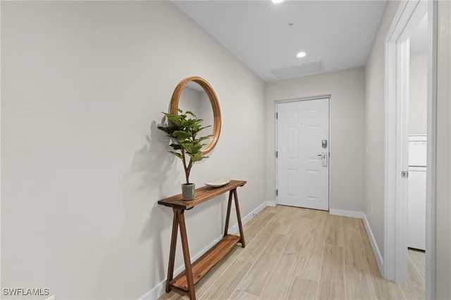 a view of a hallway with wooden floor and a potted plant