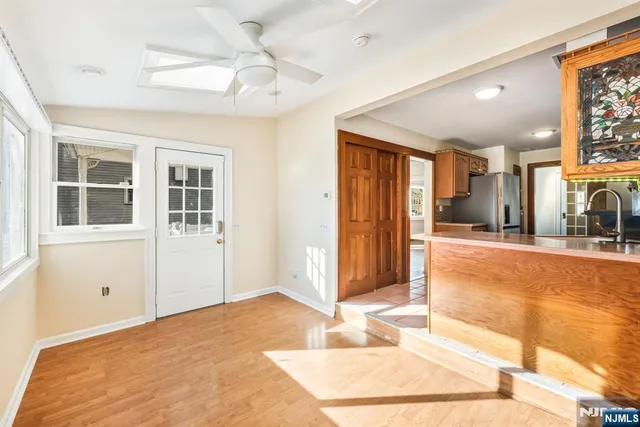 a view of a livingroom with wooden floor and a kitchen