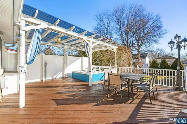 a view of a patio with table and chairs with wooden floor and fence