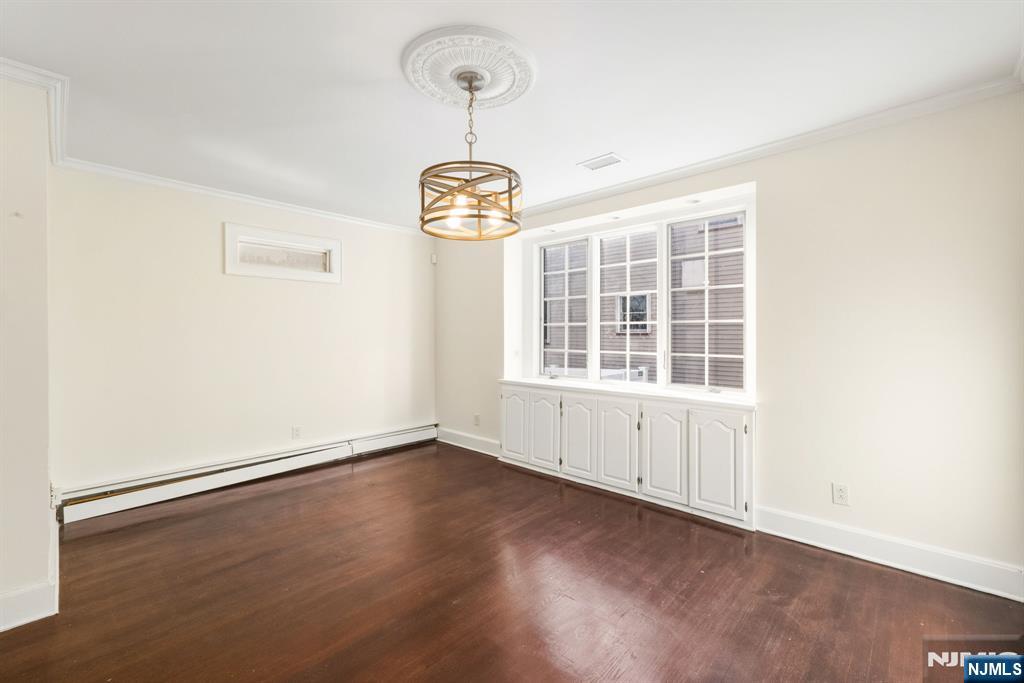 331 Mountain Way Rutherford, NJ 07070 - Photo 9 of 45 an empty room with wooden floor exposed radiator and a window