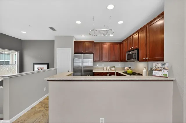 a kitchen with stainless steel appliances granite countertop a sink stove and microwave