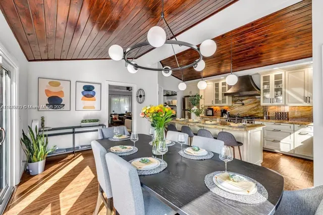 a view of a dining room with furniture a rug and wooden floor