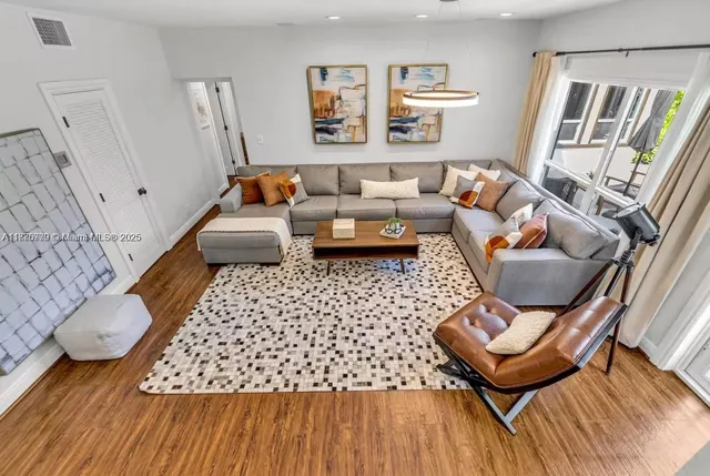 a living room with furniture and wooden floor