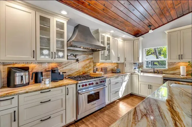 a kitchen with stainless steel appliances granite countertop a stove and a sink