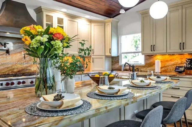 a dining room with furniture a potted plant and a mirror