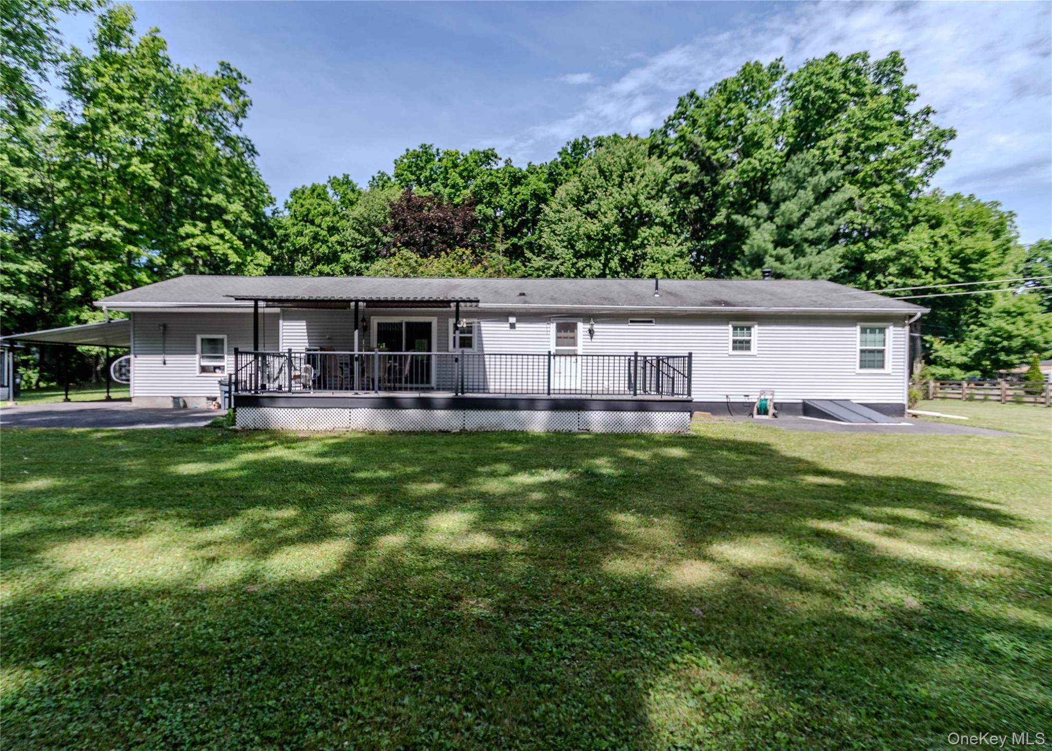 15 Van Dewark Road Middletown, NY 10941 - Photo 37 of 41 Rear exterior featuring light gray siding, a spacious elevated deck with black railings, a covered patio area, and a carport