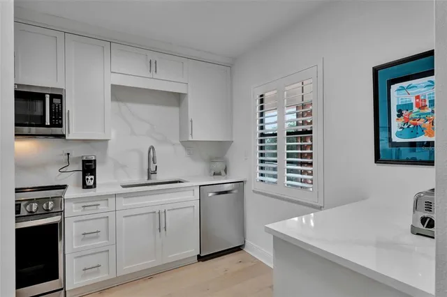 a kitchen with stainless steel appliances a sink stove and microwave