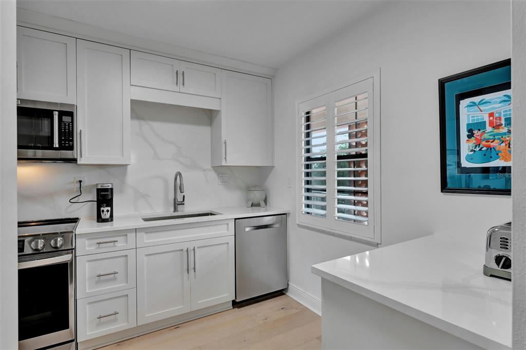 100 South Interlachen Avenue, Unit 410F Winter Park, FL 32789 - Photo 13 of 38 a kitchen with stainless steel appliances a sink stove and microwave
