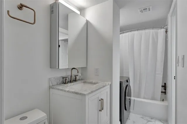 a bathroom with a granite countertop sink toilet and shower