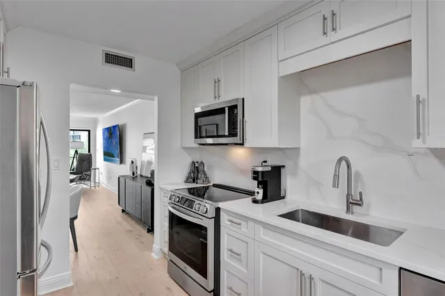 a kitchen with a sink stove and cabinets