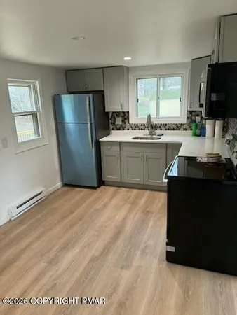 a kitchen with a refrigerator and a stove top oven