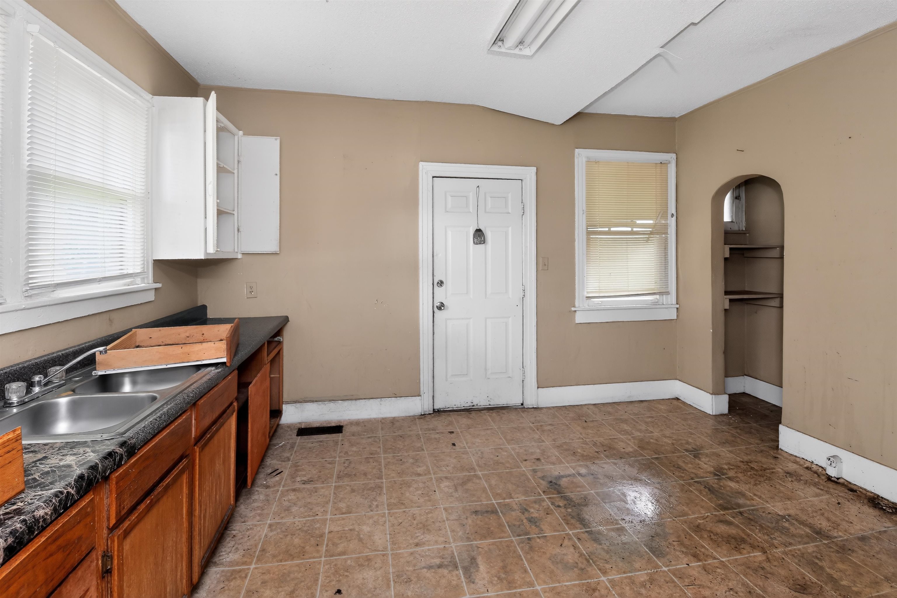 810 Hale Road Memphis, TN 38116 - Photo 15 of 30 Kitchen space with tiled flooring, a double basin stainless steel sink, wood cabinetry, and white upper cabinets