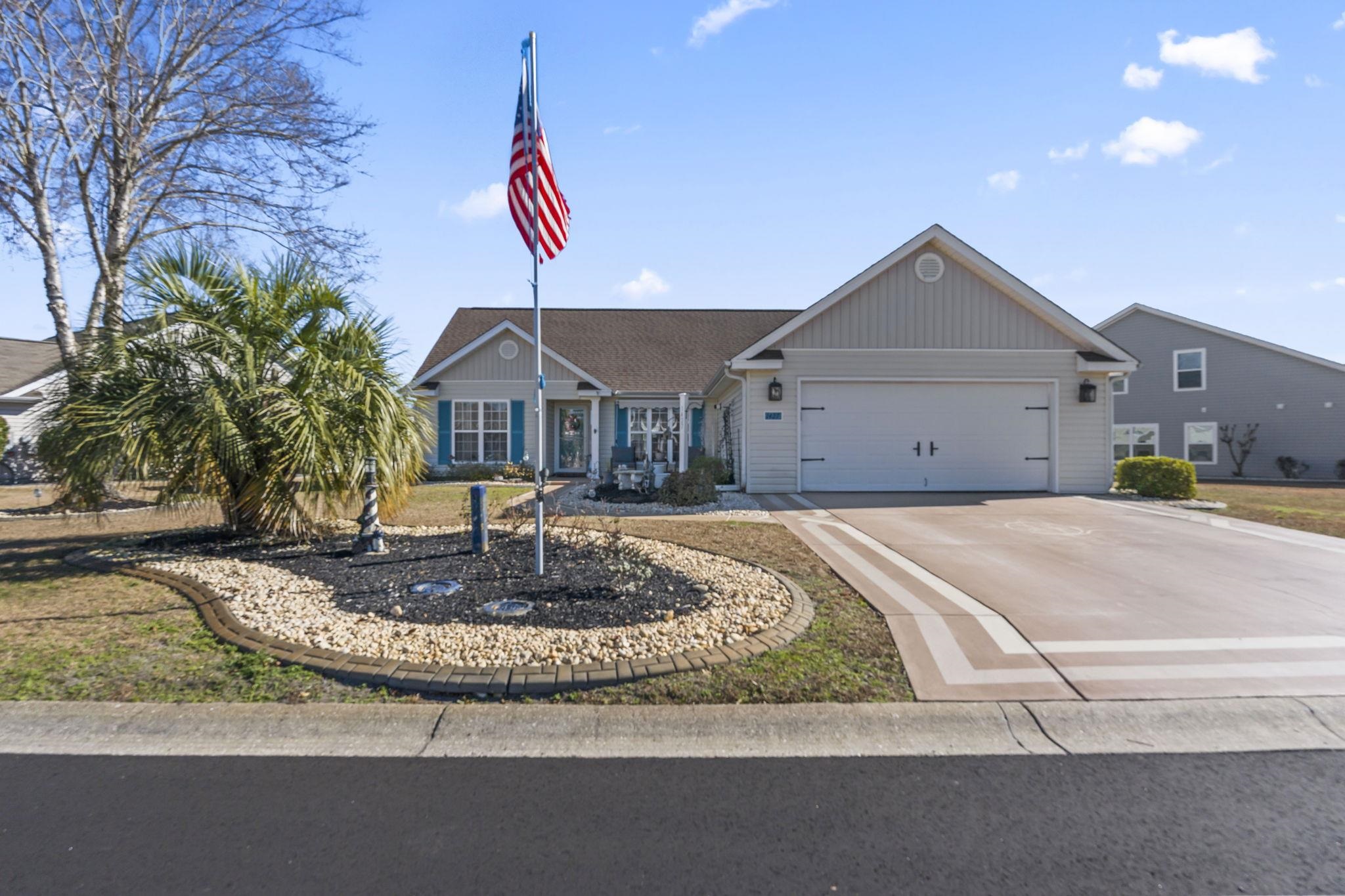 Single story home with concrete driveway, a garage, and board and batten siding