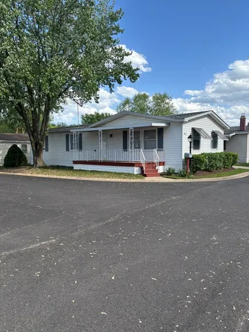 a front view of a house with a yard and trees