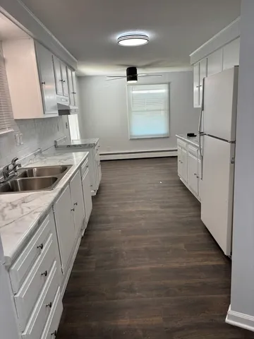 a kitchen with granite countertop a refrigerator and a sink