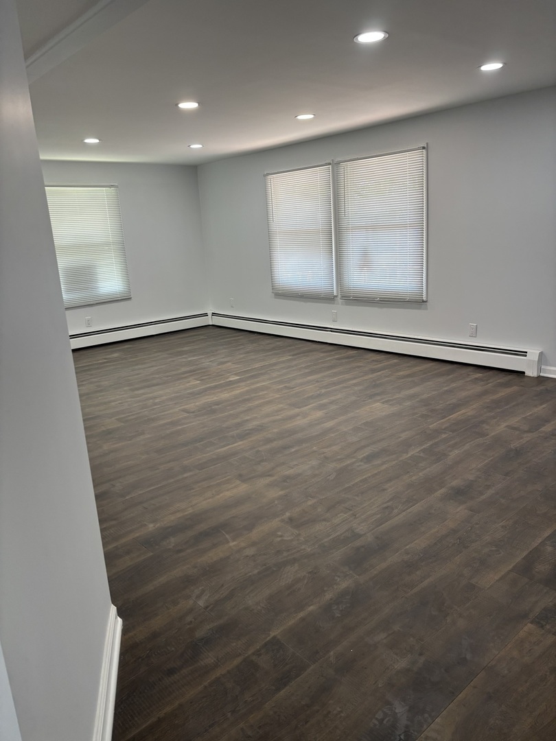 445 Lucile Avenue Elgin, IL 60120 - Photo 5 of 7 an empty room with wooden floor and windows