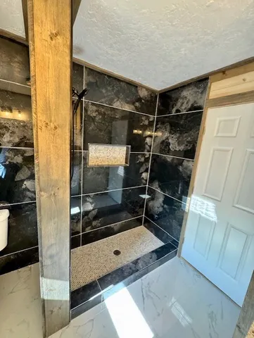 a bathroom with a glass shower door and a sink
