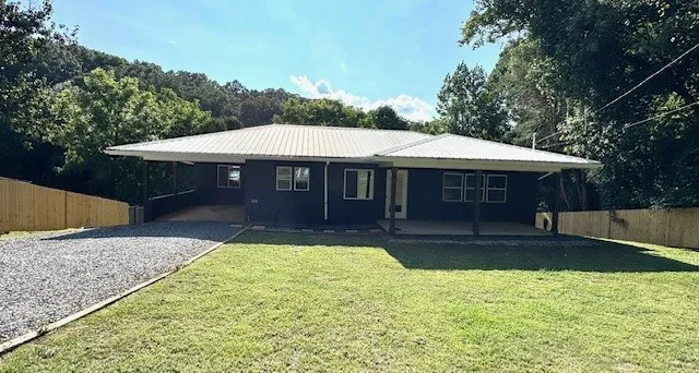 a front view of a house with a yard balcony and a large tree