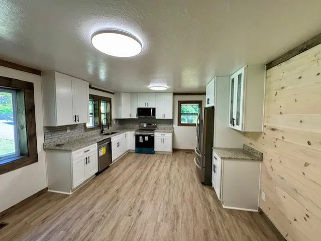a kitchen with stainless steel appliances granite countertop a refrigerator a stove top oven a sink and dishwasher
