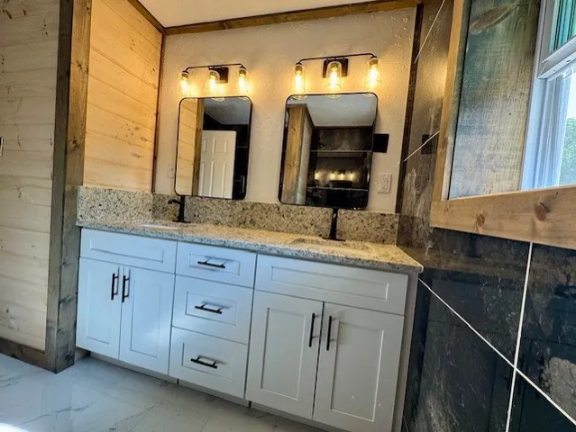 a bathroom with a granite countertop sink and a mirror