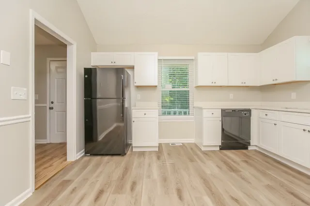 a view of a kitchen with wooden floor and a refrigerator