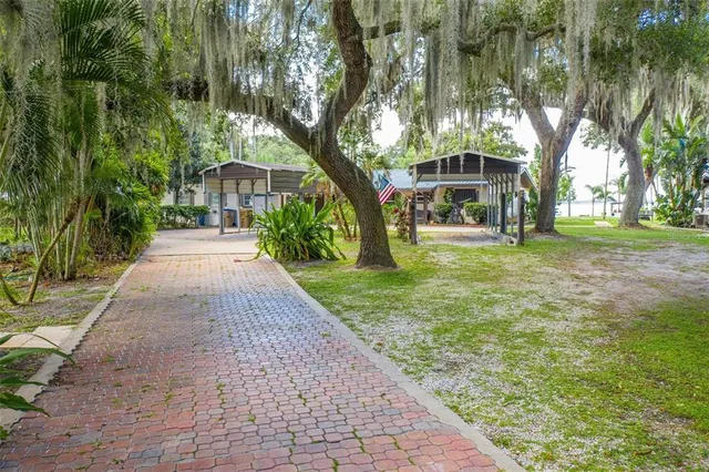 a front view of a house with a yard and trees