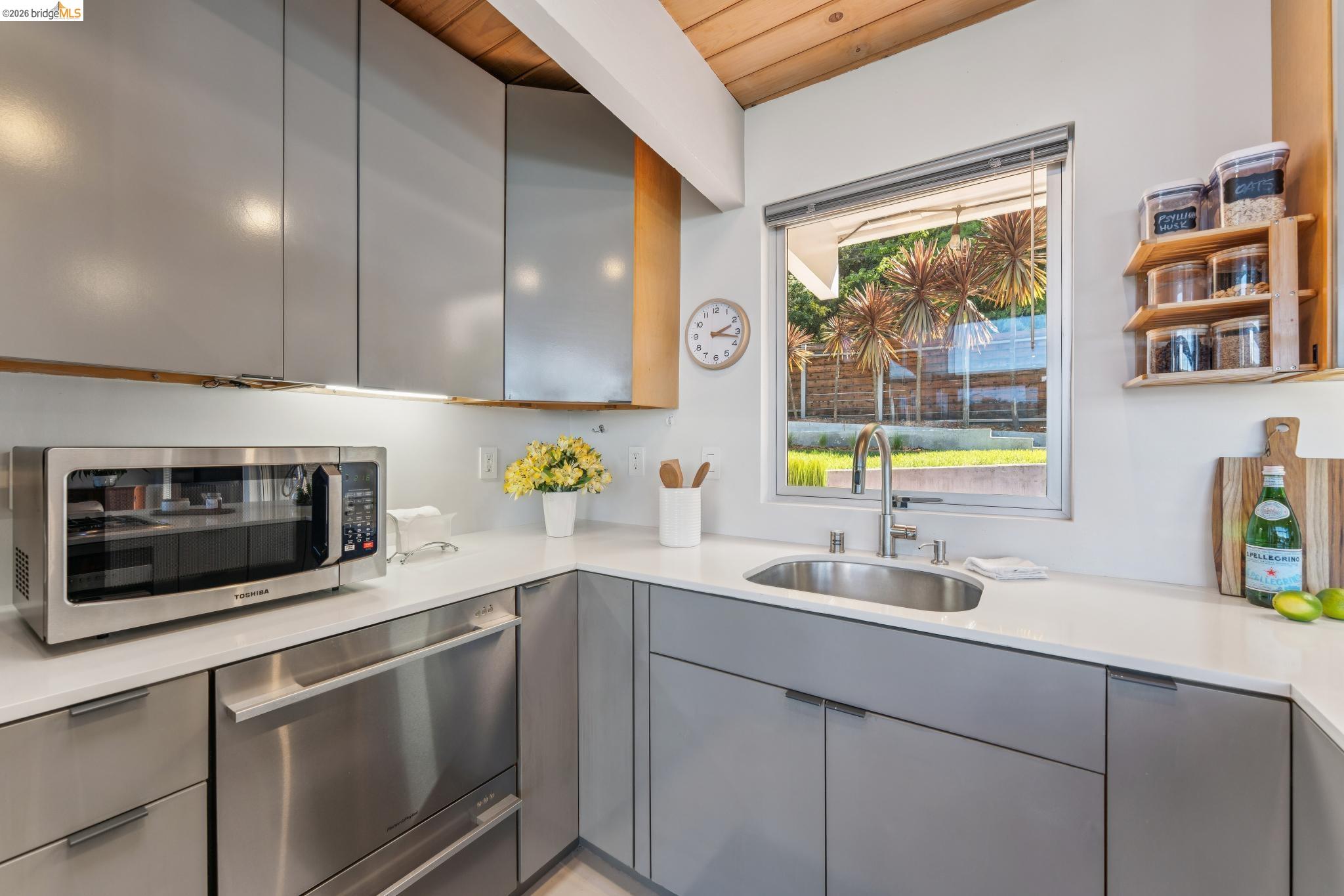6733 Snake Road Oakland, CA 94611 - Photo 14 of 57 a kitchen with stainless steel appliances a sink and a microwave