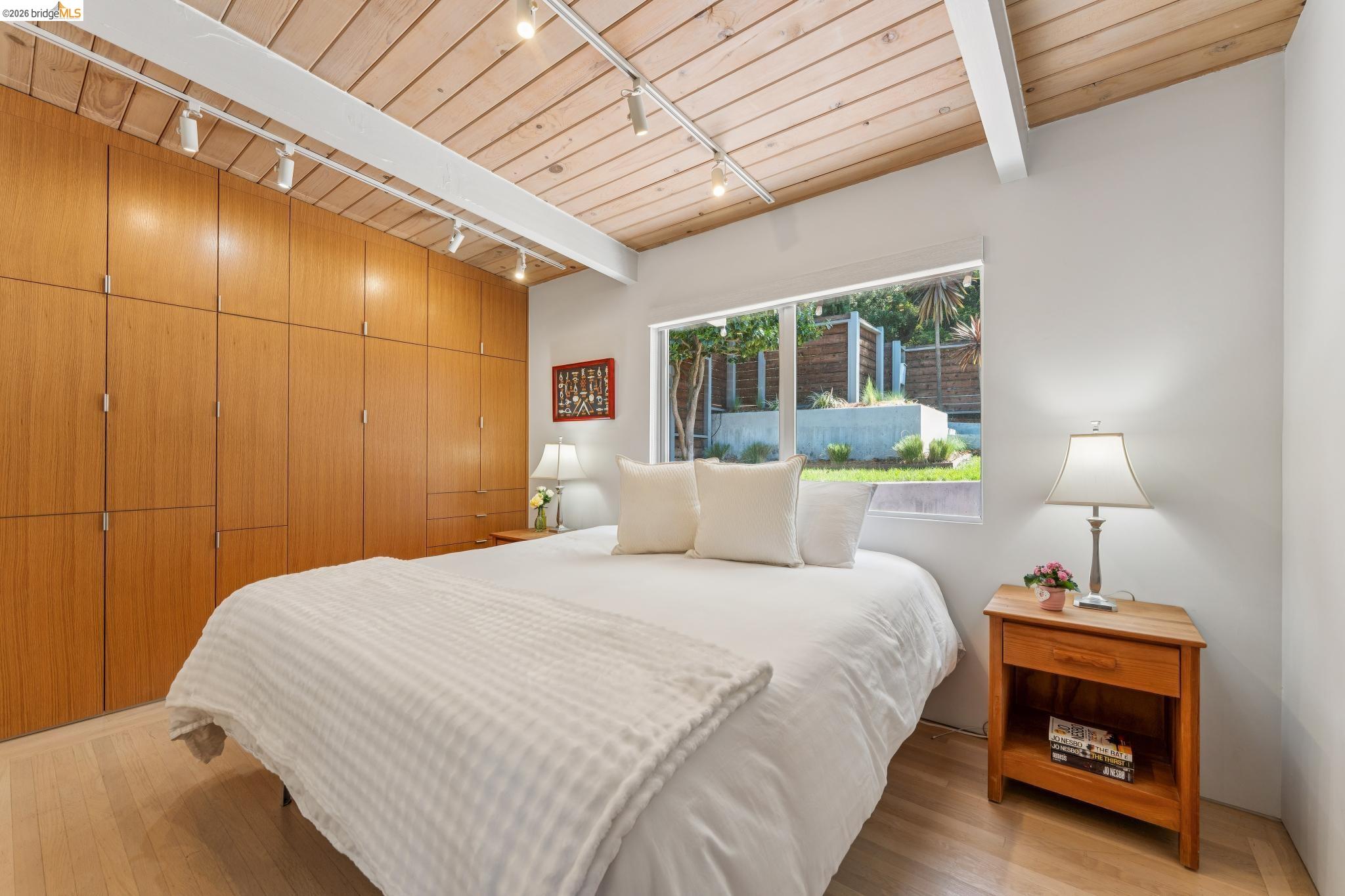 6733 Snake Road Oakland, CA 94611 - Photo 17 of 57 a bedroom with a bed and a lamp