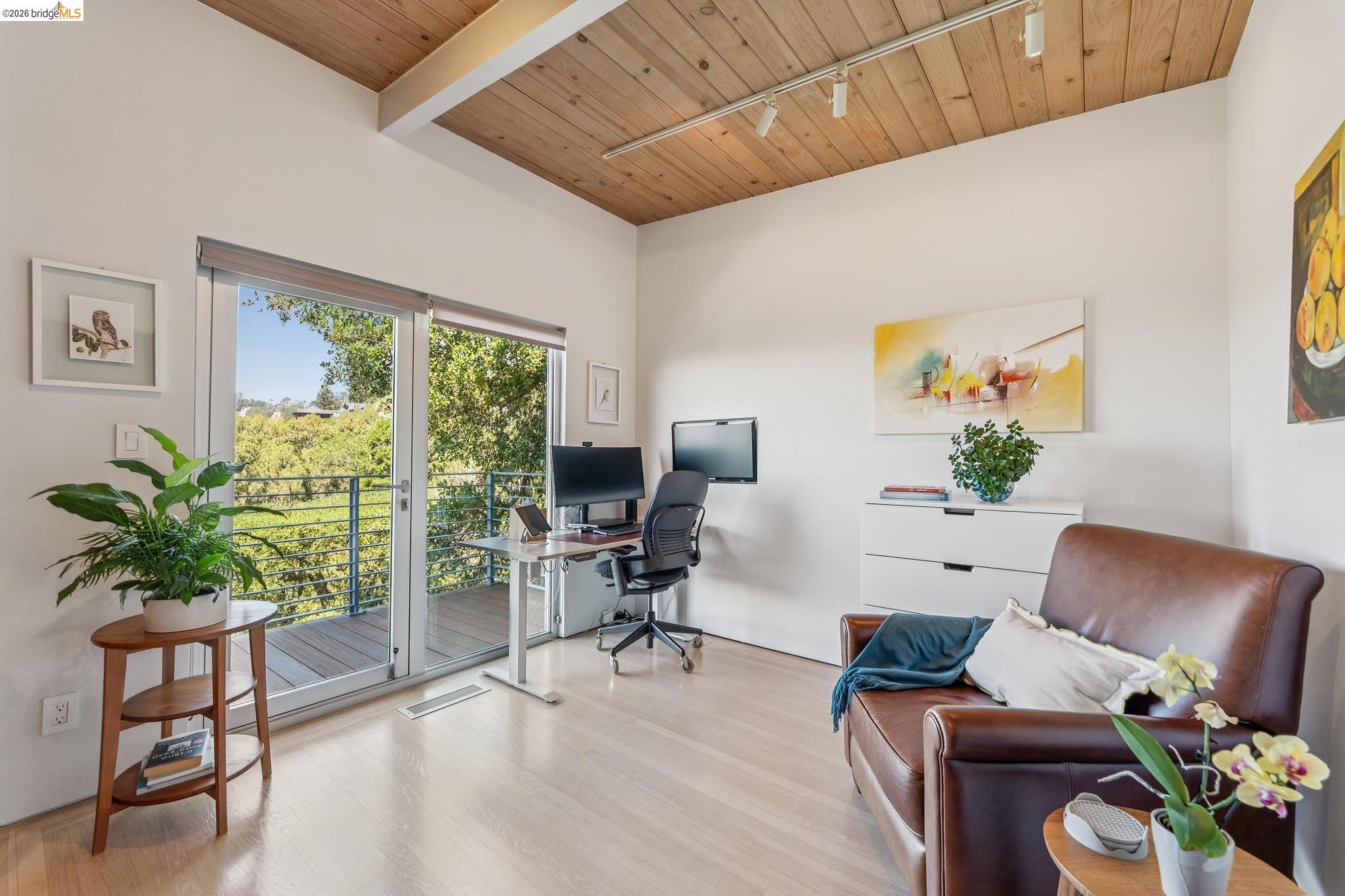 6733 Snake Road Oakland, CA 94611 - Photo 20 of 57 a living room with furniture floor to ceiling window and wooden floor